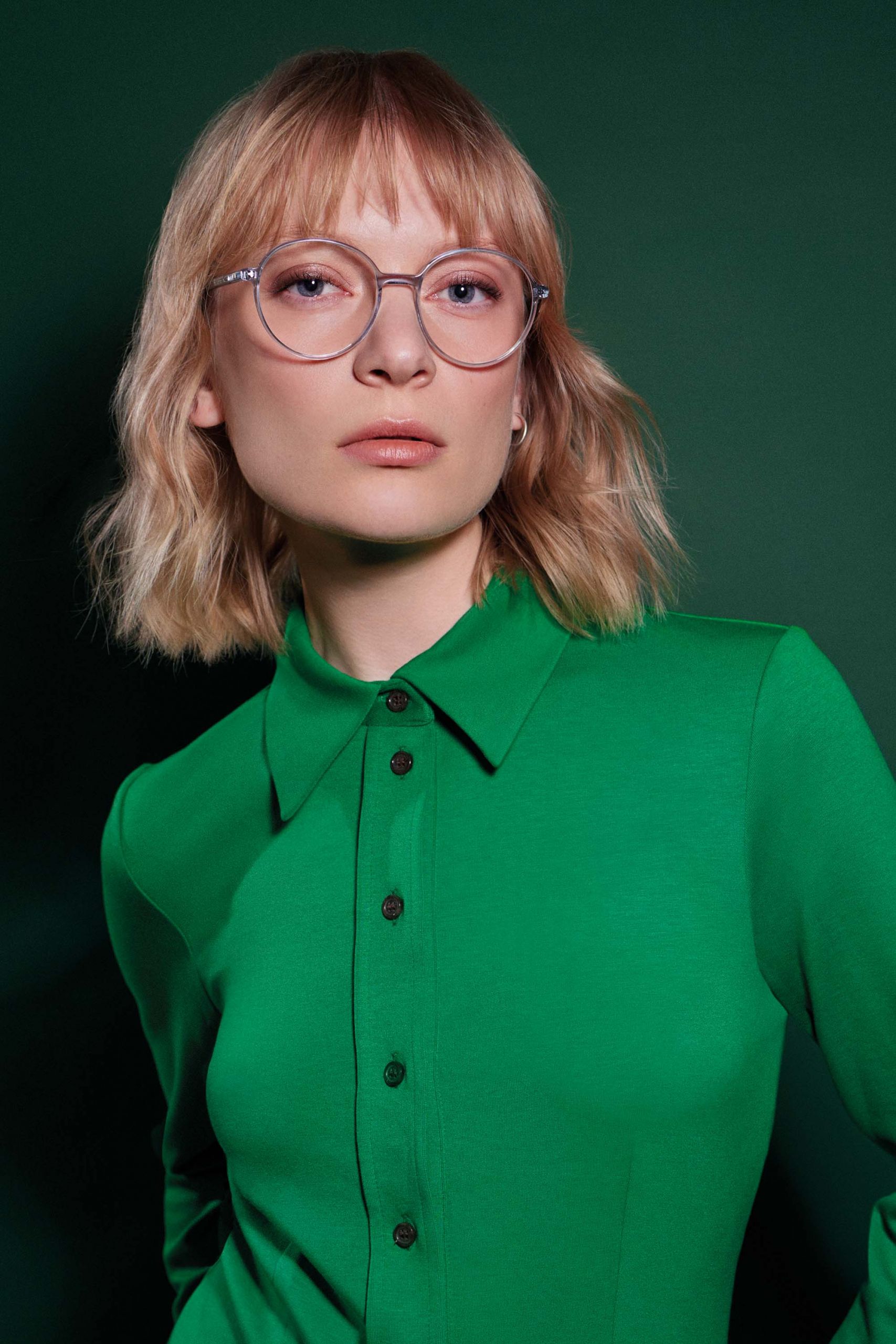 Frau mit runder Brille und grünem Hemd