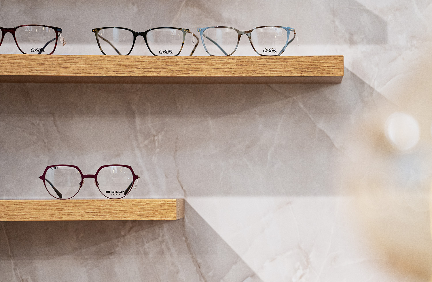 Mehrere moderne Brillen auf Holzregalen